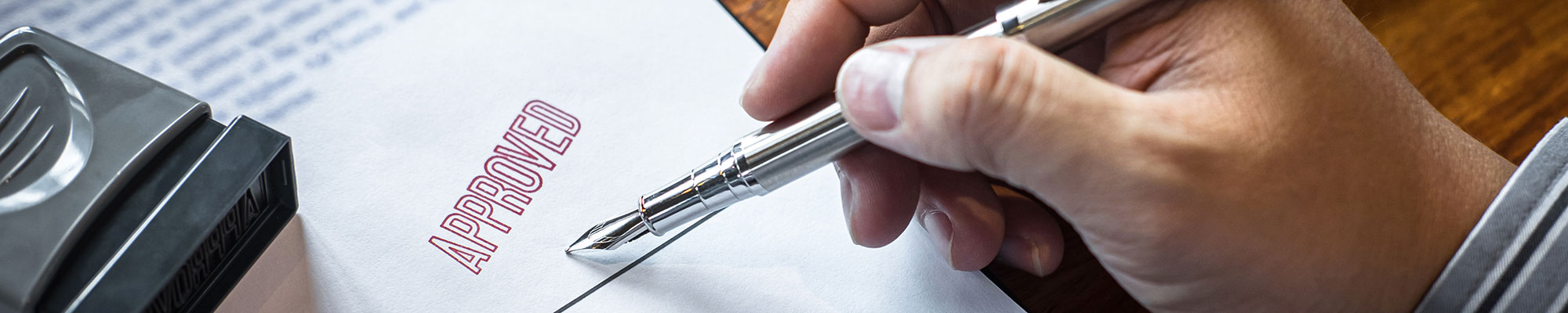 man signing a contract with a fountain pen