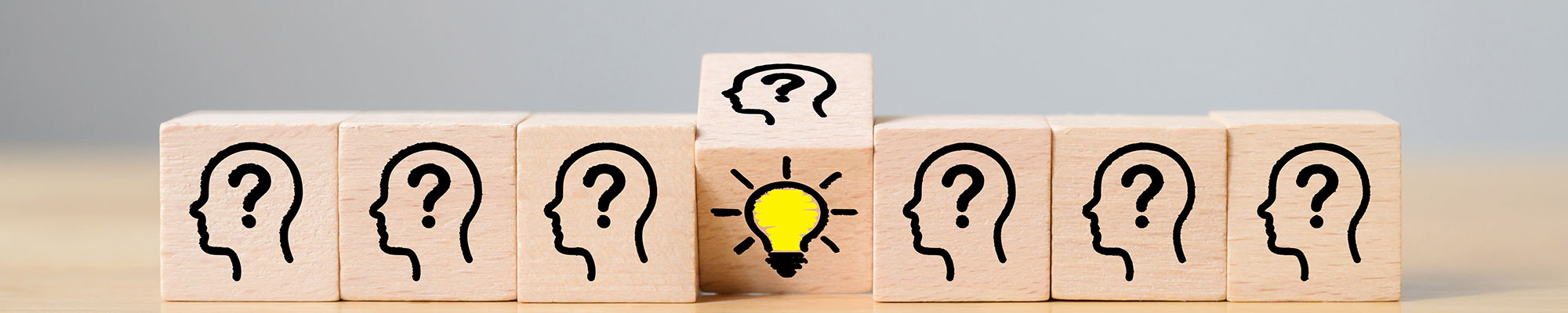 wooden blocks with question marks beside a block with an idea lightbulb